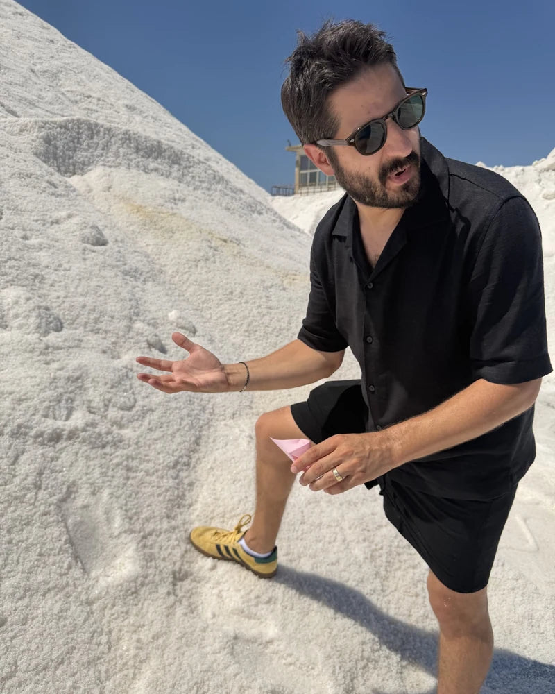 A close view of Alex examining a small sample beside a salt mound during the Italy trip