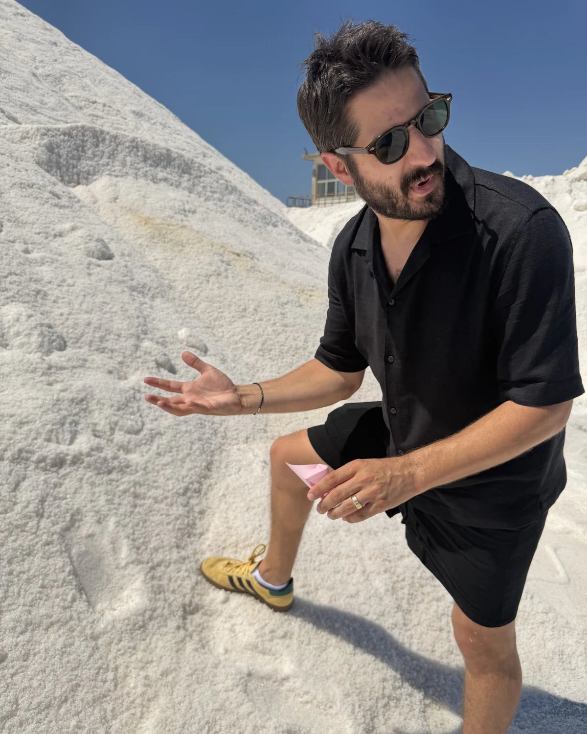 Examining a small salt sample beside a salt mound during our Italy trip