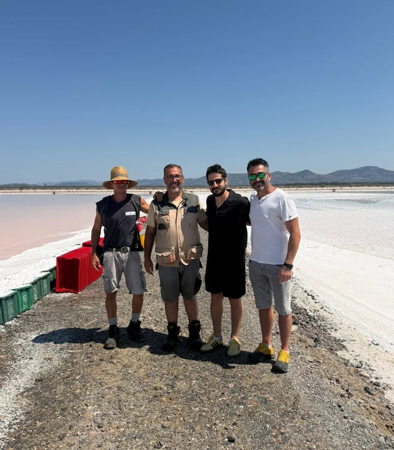 Four people beside the salt pans during a visit in Italy